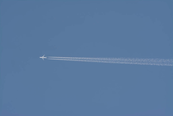 névtelen kereskedelmi repülőgép repül a kék ég felett - Fotó, kép
