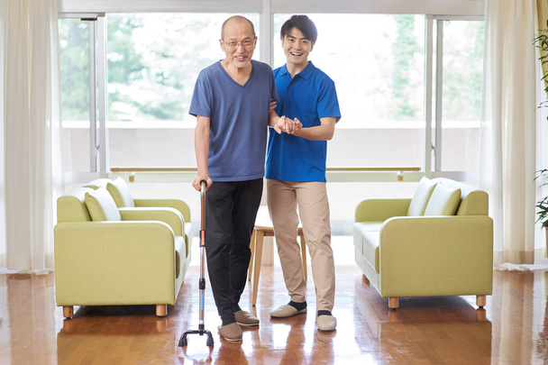 Opiekun, który pomaga starszym w chodzeniu - Zdjęcie, obraz