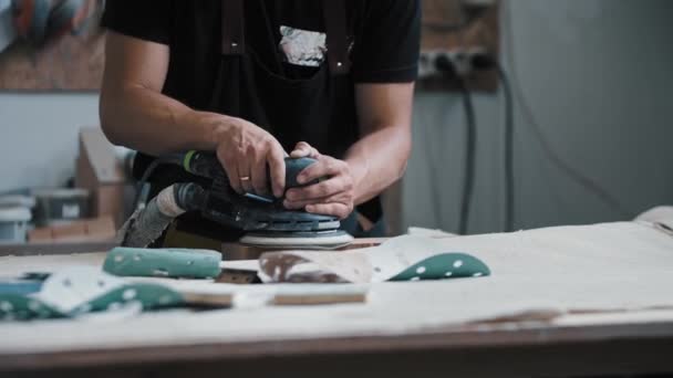 Hombre trabajador moliendo una pieza de madera en el taller con un instrumento - Metraje, vídeo