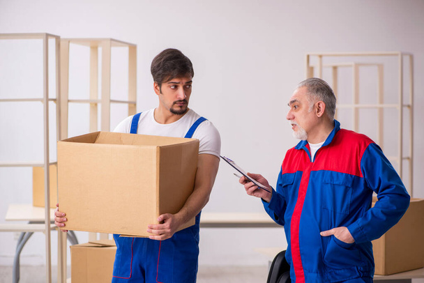 Deux déménageurs professionnels masculins faisant déménagement à la maison - Photo, image