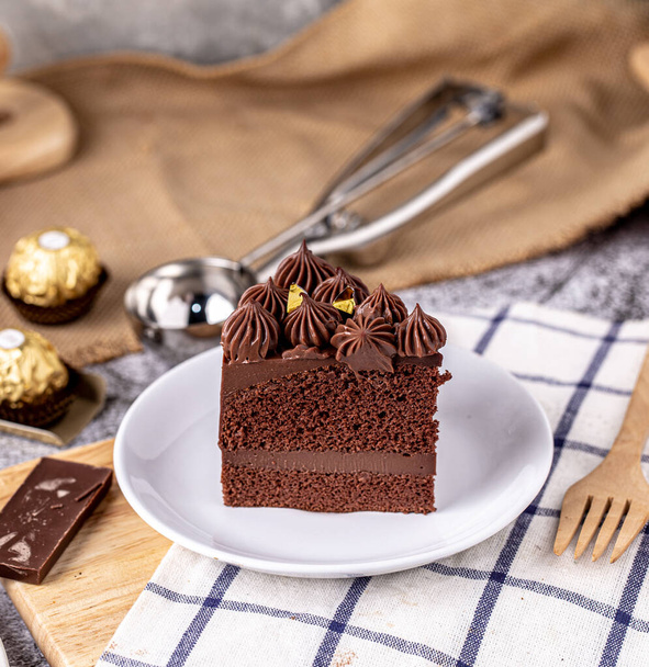 Slice of delicious homemade chocolate cake soft fudge on white plate. - Valokuva, kuva