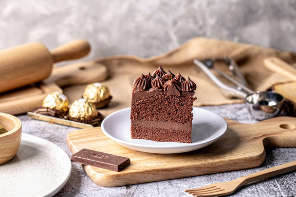 Slice of delicious homemade chocolate cake soft fudge on white plate. - Foto, Imagen