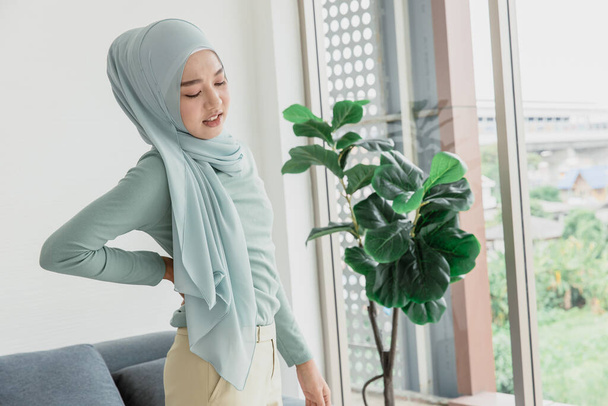 Мусульманські арабські жінки рука на спині болю, талія болюче вираження з офісного синдрому
. - Фото, зображення