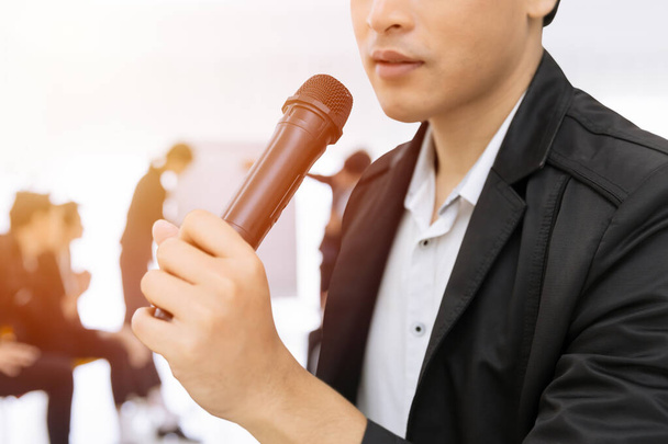 Close-up Mannelijke hand houden microfoon spreken in business seminar. Spreker lezing vergadering of talkshow concept. - Foto, afbeelding