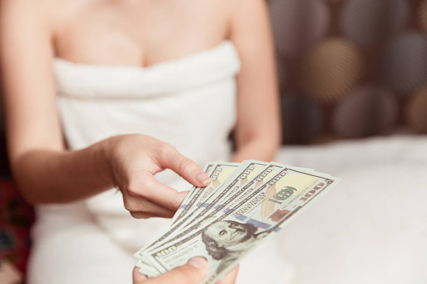 Γυναίκες νυχτερινός εργαζόμενος λαμβάνουν χρήματα από τον πελάτη πληρώνουν για την προσωπική υπηρεσία μασάζ στο δωμάτιο του ξενοδοχείου. - Φωτογραφία, εικόνα