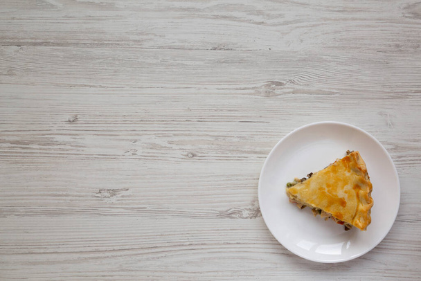 Um pedaço de torta de frango em um prato branco, vista superior. Deitado, por cima, de cima. Espaço para texto. - Foto, Imagem