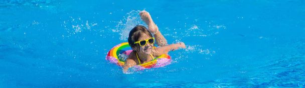 The child swims with a circle in the pool. Selective focus. Kid. - Foto, imagen