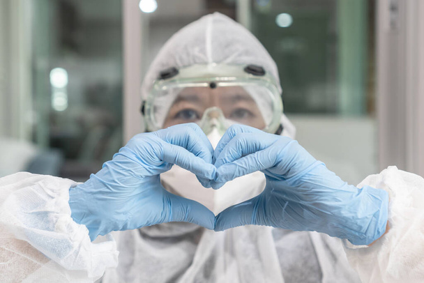 Sağlık, hayat sigortası, organ bağışı, dünya kalp sağlığı günü konsepti için kalp şeklinde elleri olan kişisel koruyucu ekipman laboratuvarında tıbbi doktor veya bilim adamı.  - Fotoğraf, Görsel