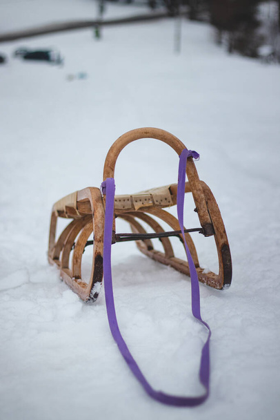 下り坂を運転するための典型的なツール。紫のストラップと木製の歴史的なそり。山の中で冬の楽しみ。チェコ共和国. - 写真・画像
