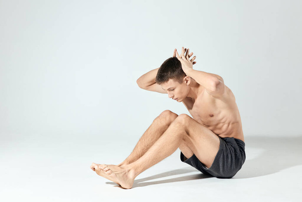 atleet doet push-ups binnen en handen achter het hoofd fitness opgepompt romp - Foto, afbeelding