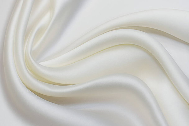 Milky-colored silk fabric in artistic layout. Texture, background, pattern. - Photo, Image