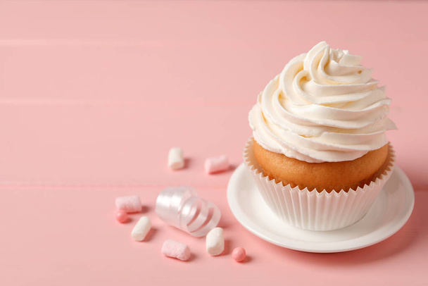 Delicious cupcake decorated with cream on pink background, space for text - Photo, Image