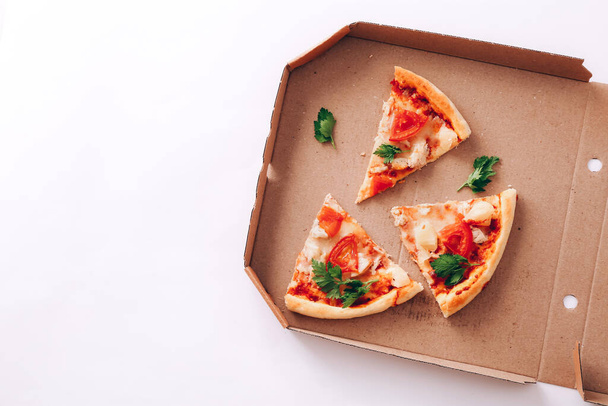 Piezas de pizza en caja de entrega sobre fondo blanco - Foto, imagen