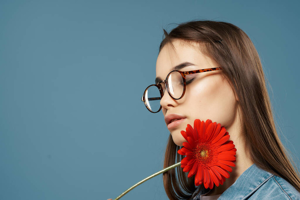 девушка с цветком рядом с ее лицом очки гламур крупным планом - Фото, изображение