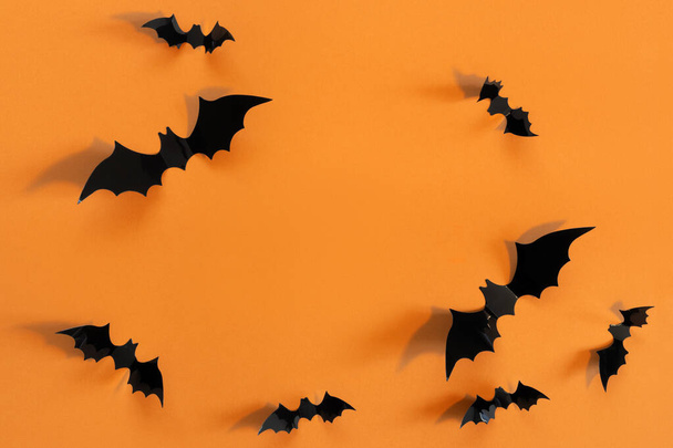 Halloween card with black bats on orange background. Banner for congratulations or invitation. - Foto, Imagem