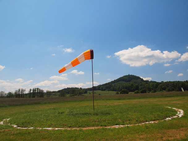 Yaz spor Havaalanı ile terk edilmiş windsoc sıcak günde, Rüzgar esiyor ve Rüzgar gülü hareket ediyor - Fotoğraf, Görsel