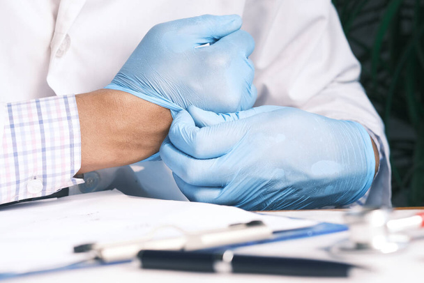 man doctor wears medical gloves, close up - Фото, изображение