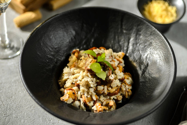 chanterelle risotto in a black plate. High quality photo - Foto, afbeelding