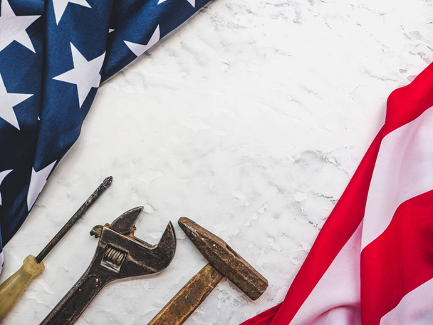 LABOR DAY. Hand tools and the Flag of the United States of America lying on the table. View from above, close-up. Congratulations to family, relatives, friends and colleagues. National holiday concept - Photo, image