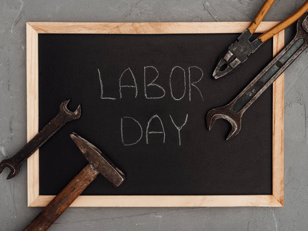LABOR DAY. Hand tools lying on the table. View from above, close-up. Preparing for the celebration. Congratulations to loved ones, family, relatives, friends and colleagues. National holiday concept - Фото, зображення