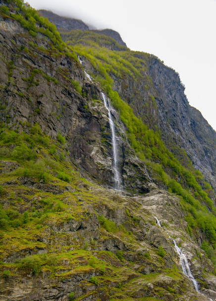 Petite cascade peu abondante sur le flanc de la montagne. Vue panoramique d'une cascade lors d'une croisière dans le fjord en Norvège. - Photo, image