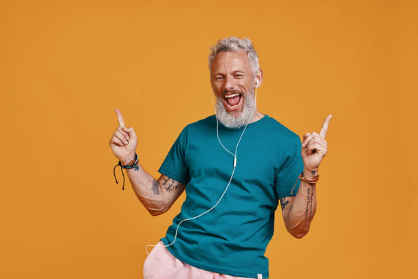 Happy senior man in headphones listening music and smiling - Fotografie, Obrázek