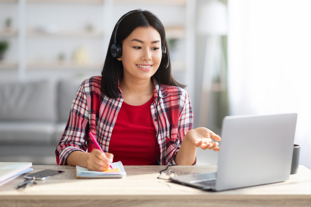 Educación a distancia. Joven asiática estudiante viendo webinar en el ordenador portátil en casa - Foto, imagen
