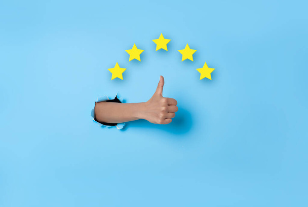 Customer Experience Woman hand thumb up vote on five star excellent rating on blue background. Review and feedback concept. - Photo, Image