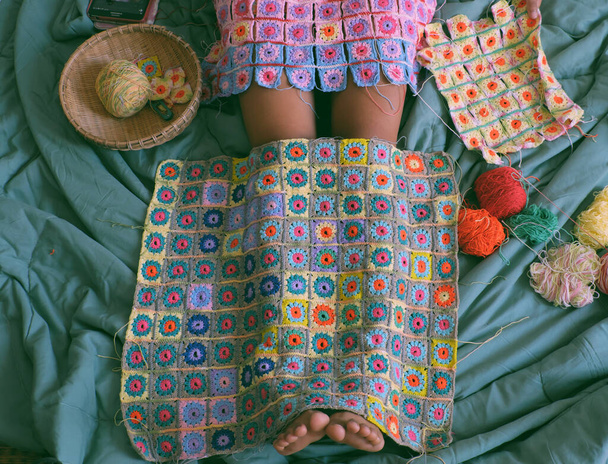 Top vue femme jambes avec produit fait main pour chaud en hiver, couverture colorée au crochet par lien de nombreuses œuvres d'art pour faire de belles formes graphiques à partir de fil. - Photo, image