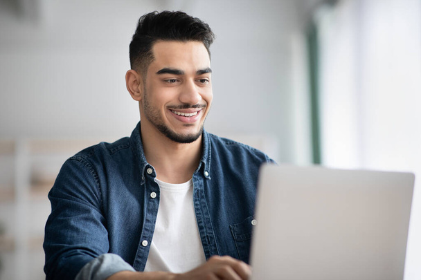 zbliżenie szczęśliwy arabski facet pracuje z laptop w biuro - Zdjęcie, obraz