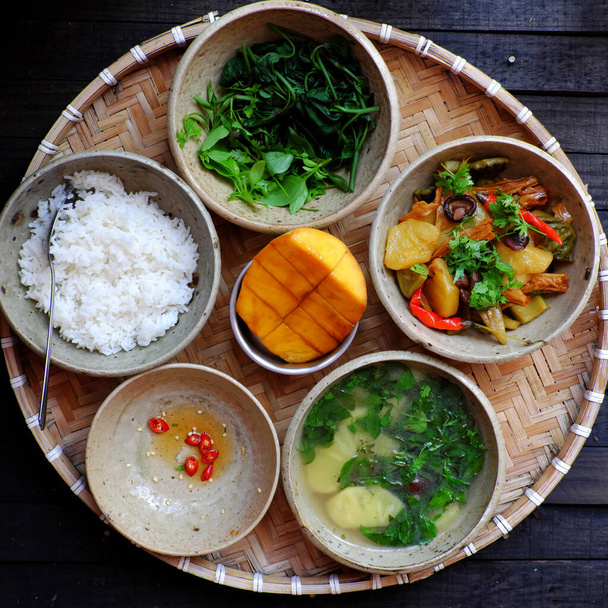 Top view vietnamilainen päivittäinen ateria lounaaksi, tarjotin riisiruokaa keitetyillä bataattisilmukoilla, ananaskeitto, tofu iho, ananas, sienet kokki kastikkeella, vegaaninen menu, jossa ei ole lihaa hyvää terveydelle  - Valokuva, kuva