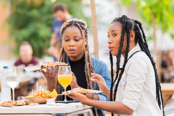 Talking afro amerikkalaiset naiset tilalla herkullisia pizza viipaleita: Valikoiva keskittyä - Valokuva, kuva
