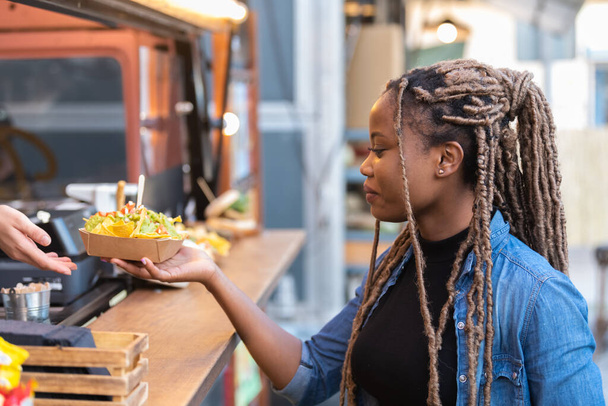 Afro amerykanka dostaje tacę fast food z fast food truck - Zdjęcie, obraz