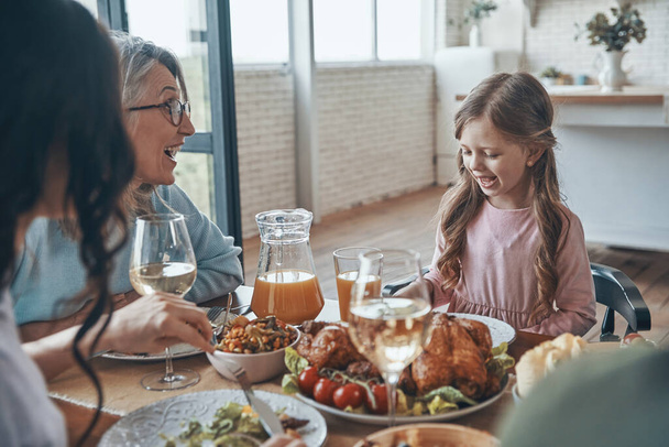 Happy multi-generation family communicating and smiling while having dinner together - Valokuva, kuva