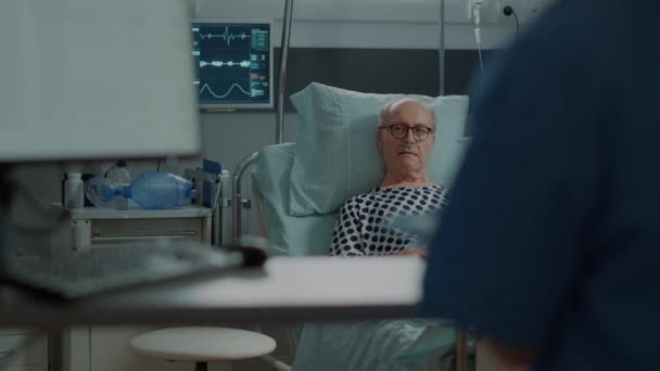 Enfermera hablando con paciente viejo enfermo en la sala del hospital en la unidad - Imágenes, Vídeo