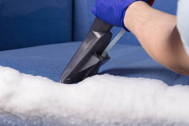 the vacuum cleaner collects foam for dry cleaning of upholstered furniture side view, close-up - 写真・画像