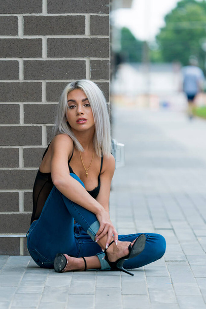 Un magnifique modèle blond pose à l'extérieur dans un environnement urbain - Photo, image