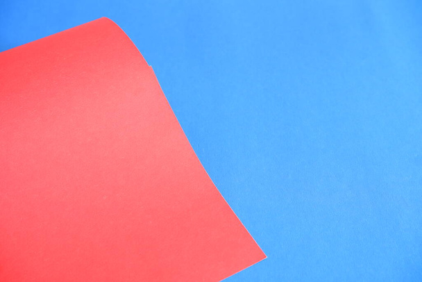 Red cardboard on a blue background. The texture of the cardboard. - Фото, зображення