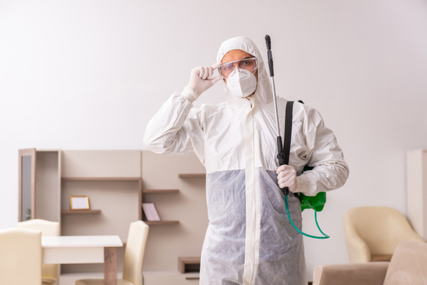 Joven contratista masculino haciendo control de plagas en casa - Foto, imagen