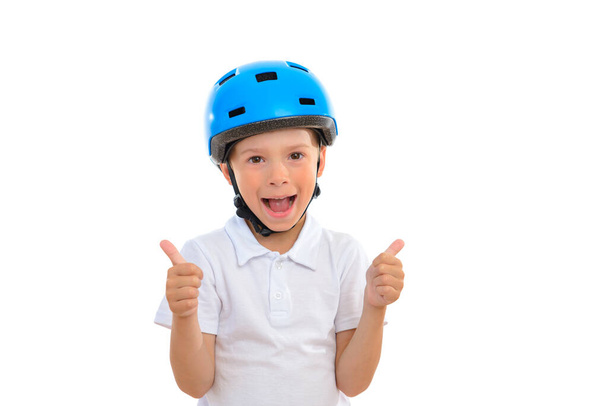 A joyful child in a blue bicycle helmet shows a thumbs up gesture. Dressed in a white short sleeve shirt. White isolated background - Foto, Bild
