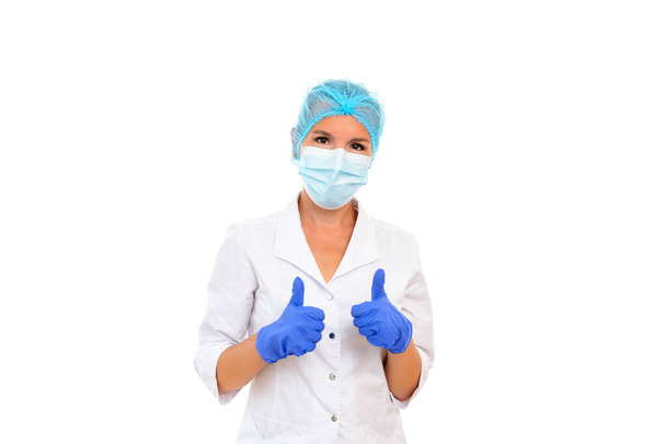Female doctor showing thumbs up gesture. The concept of victory over coronavirus, success in treatment, optimistic attitude. Portrait on a white isolated background. - Fotografie, Obrázek