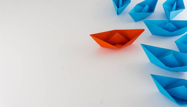Red boat origami leading a group of blue boats origami leadership concept - Photo, Image