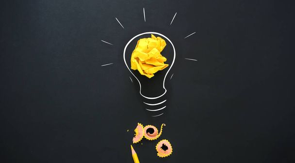 Žárovka se zmačkaným barevným papírem a žlutou tužkou - Fotografie, Obrázek