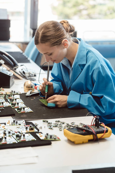 Trabalhador na fabricação de eletrônicos soldando um componente - Foto, Imagem