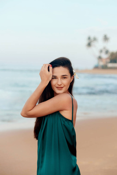 Woman with beauty face touching skin . Beautiful smiling girl model on the beach. Young smiling woman outdoors portrait.  - Foto, imagen