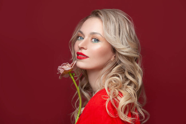 Summer beauty. Happy blonde woman with flower on red background - Fotografie, Obrázek