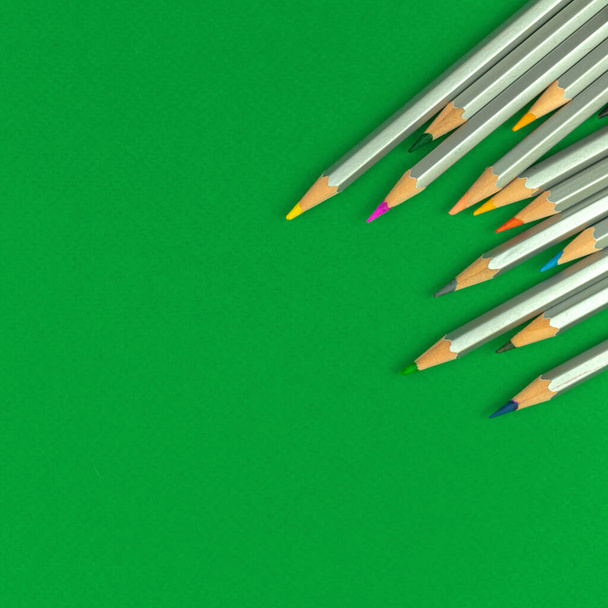 Schule grünen Tisch Desktop mit bunten Bleistiften. Quadratisches Foto mit Papeterie zum Zeichnen. Kopierraum und Foto von oben - Foto, Bild