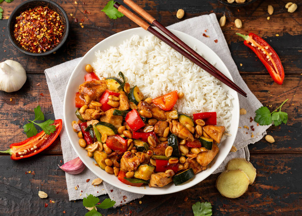 Kurczak Kung Pao z papryką, cukinią i ryżem. Azjaci zabierają jedzenie - Zdjęcie, obraz
