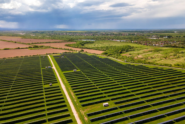 Luchtfoto van een grote duurzame elektriciteitscentrale met vele rijen zonnepanelen voor het produceren van schone ecologische elektrische energie. Hernieuwbare elektriciteit zonder uitstoot. - Foto, afbeelding