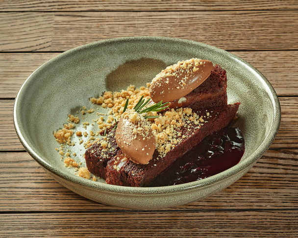 Chocolate cake with cream mousse, berry compote and nut crumbs - Photo, Image